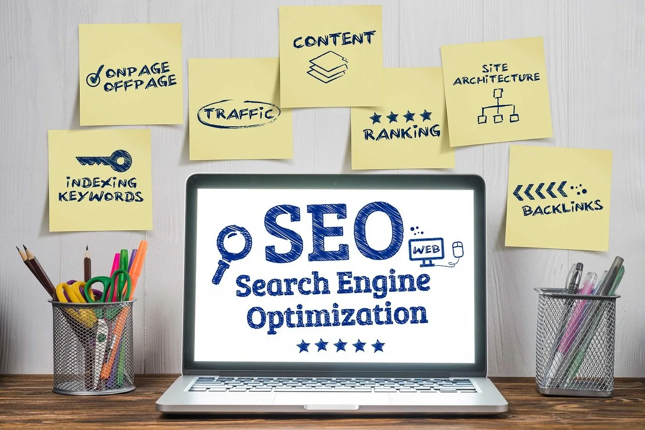 Ordinateur portable affichant « SEO – Search Engine Optimization », entouré de notes : mots-clés, contenu, liens, positionnement